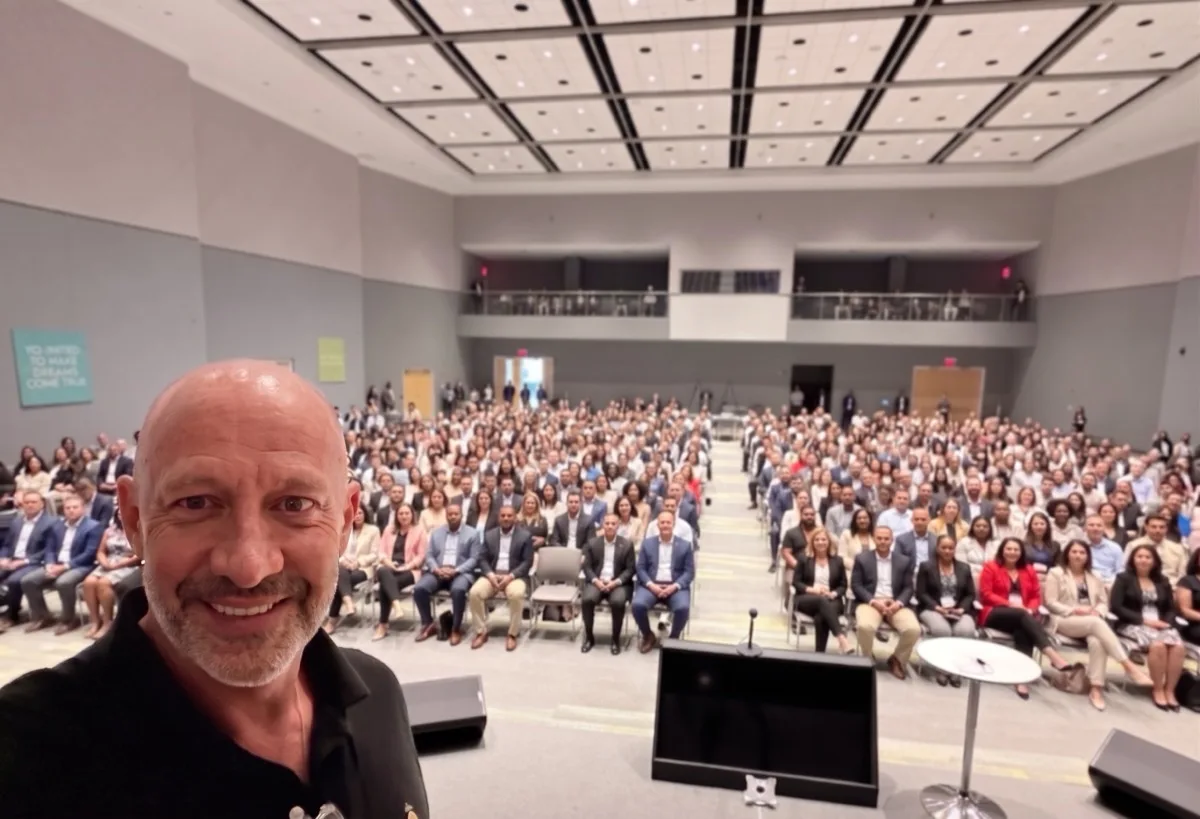 Chris Daigle on stage in front of a packed executive audience